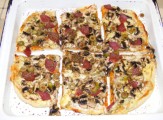 Pizza - Kész (szalámis), tepsiben, felvágva.